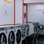 Inside a laundromat with washing machines lined up against the wall.