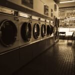 Sepia-toned image of a laundromat interior showcasing a row of classic washing machines.
