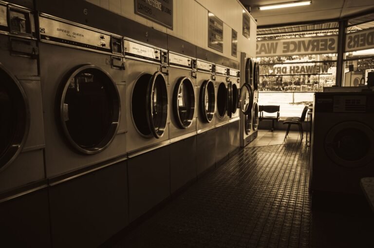 Sepia-toned image of a laundromat interior showcasing a row of classic washing machines.