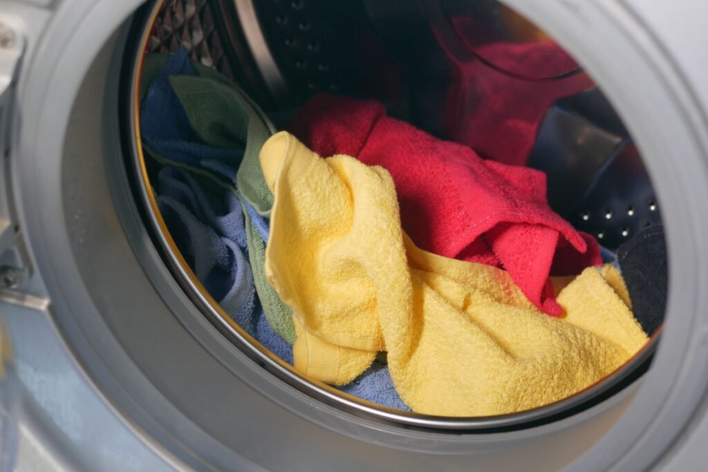 Vibrant close-up of multicolored towels inside a washing machine, ready for a wash.
