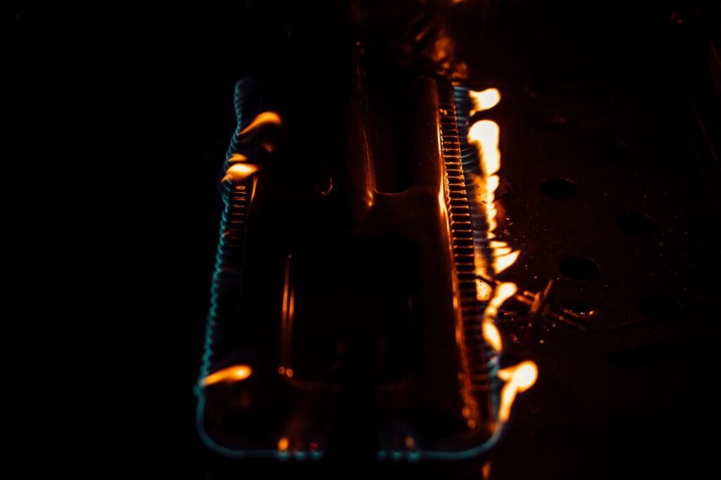 Close-up of flames on a gas burner. Dark and intense atmosphere with glowing fire.