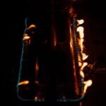 Close-up of flames on a gas burner. Dark and intense atmosphere with glowing fire.