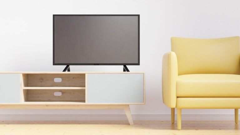 Minimalist living room featuring a flat screen TV, yellow armchair, and stylish wooden furniture.