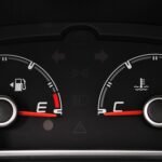 Detailed view of a car's fuel and temperature gauges on dashboard.
