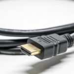 A detailed image of a black HDMI cable with gold connectors on a white background.
