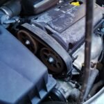 Detailed close-up of a car engine focusing on the belts and components under the hood.