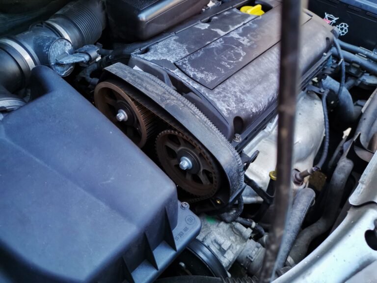 Detailed close-up of a car engine focusing on the belts and components under the hood.