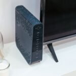 A sleek home technology setup featuring a router, glass decoration, and television.