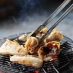 Fresh seafood being grilled on a charcoal barbecue in Rạch Giá, Vietnam.