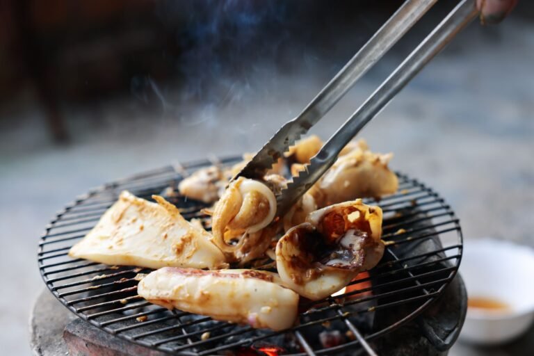 Fresh seafood being grilled on a charcoal barbecue in Rạch Giá, Vietnam.
