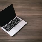 Sleek open laptop placed on a polished wooden floor, showcasing modern technology design.