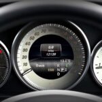 Close-up image of a car dashboard highlighting speedometer, odometer, and temperature gauge.