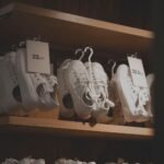 White sneakers elegantly displayed in a modern shop interior, showcasing minimalistic design on wooden shelves.