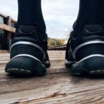 Close-up of athletic sneakers on a wooden bridge, capturing a runner's morning exercise routine.