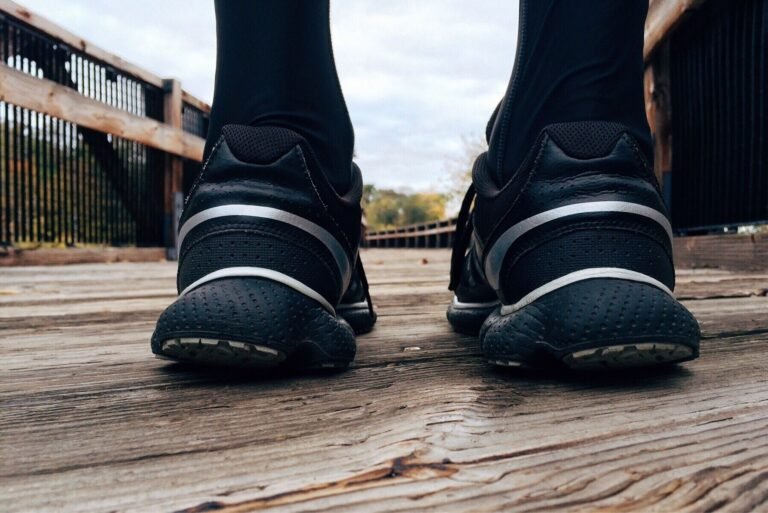 Close-up of athletic sneakers on a wooden bridge, capturing a runner's morning exercise routine.