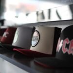 Collection of trendy baseball caps arranged on a store shelf, showcasing different designs.