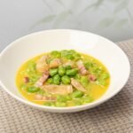 A bowl of savory fava bean and bacon stew, perfect for a comforting meal.