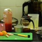 A kitchen counter with fresh citrus fruits, juice containers, and a juicer for home cooking inspiration.