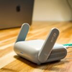 A sleek WiFi 6 router with antennas and cable on a wooden desk, perfect for modern home networks.