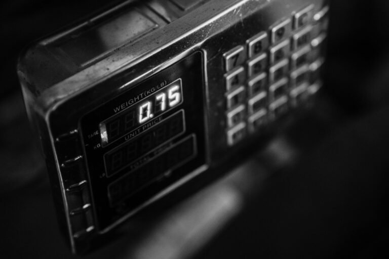 Close-up of a digital weight scale in black and white, showcasing measurement settings.