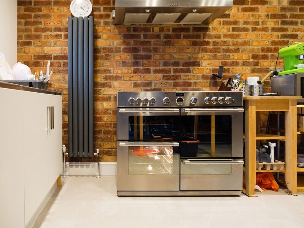 Stylish kitchen featuring a stainless steel oven, exposed brick wall, and contemporary appliances.