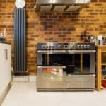 Stylish kitchen featuring a stainless steel oven, exposed brick wall, and contemporary appliances.