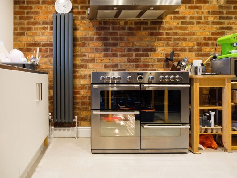 Stylish kitchen featuring a stainless steel oven, exposed brick wall, and contemporary appliances.