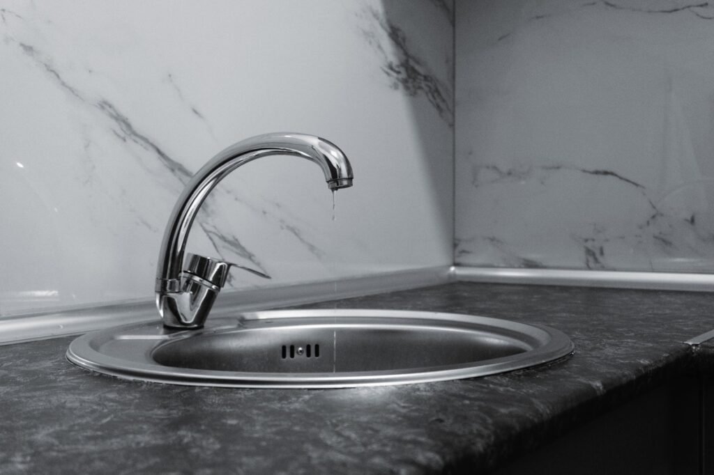 A clean and modern kitchen sink with a chrome faucet, highlighting minimalist design and water conservation.