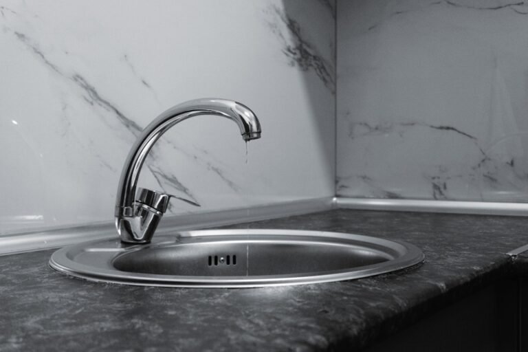A clean and modern kitchen sink with a chrome faucet, highlighting minimalist design and water conservation.