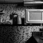 Black and white kitchen scene featuring an Electrolux microwave and various kitchen items, perfect for domestic lifestyle themes.