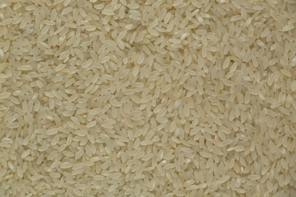 Close-up of uncooked white rice grains showing texture and detail, ideal for culinary themes.