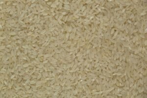 Close-up of uncooked white rice grains showing texture and detail, ideal for culinary themes.