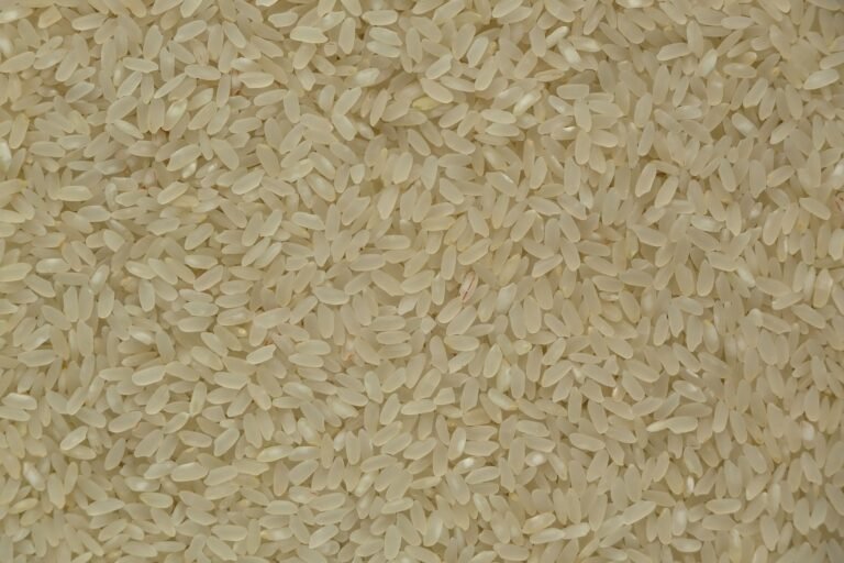 Close-up of uncooked white rice grains showing texture and detail, ideal for culinary themes.