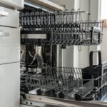 Open and empty dishwasher in a sunlit modern kitchen ready for use.