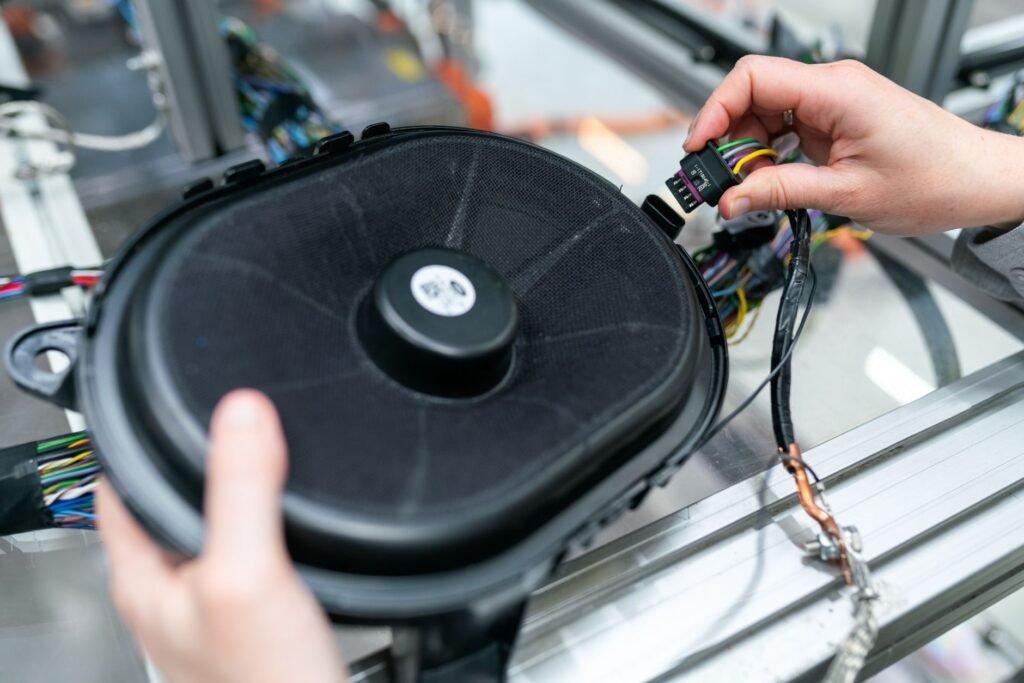 Close-up of an engineer working on a sound system speaker assembly in a workshop.