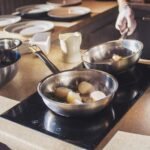 Chef preparing delicious scallops with herbs in modern kitchen setting. Culinary art captured indoors.