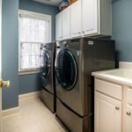 A clean, organized laundry room featuring modern appliances and ample storage.