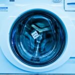 Close-up of an out-of-service washing machine in a laundromat with a blue tint.