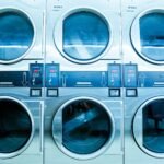 A row of modern washing machines in a launderette, showcasing contemporary laundry technology.