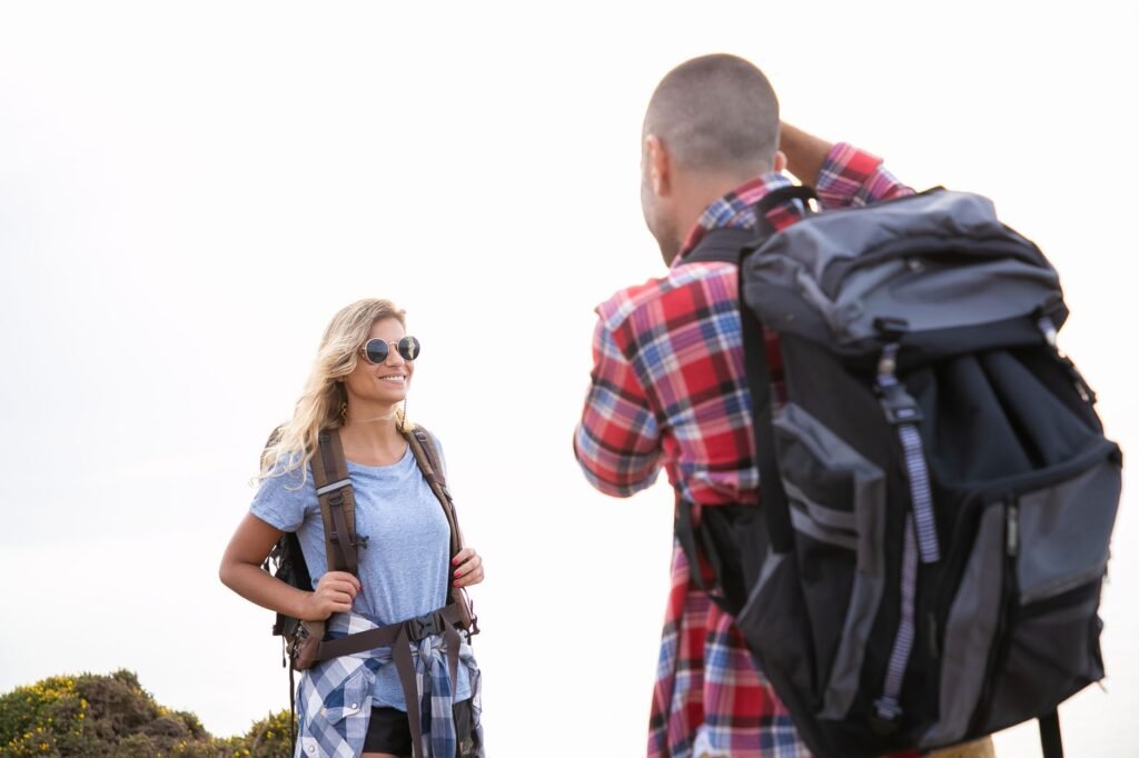 Happy couple hiking with backpacks in sunny Portugal. Enjoying outdoor adventure together.