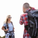 Happy couple hiking with backpacks in sunny Portugal. Enjoying outdoor adventure together.