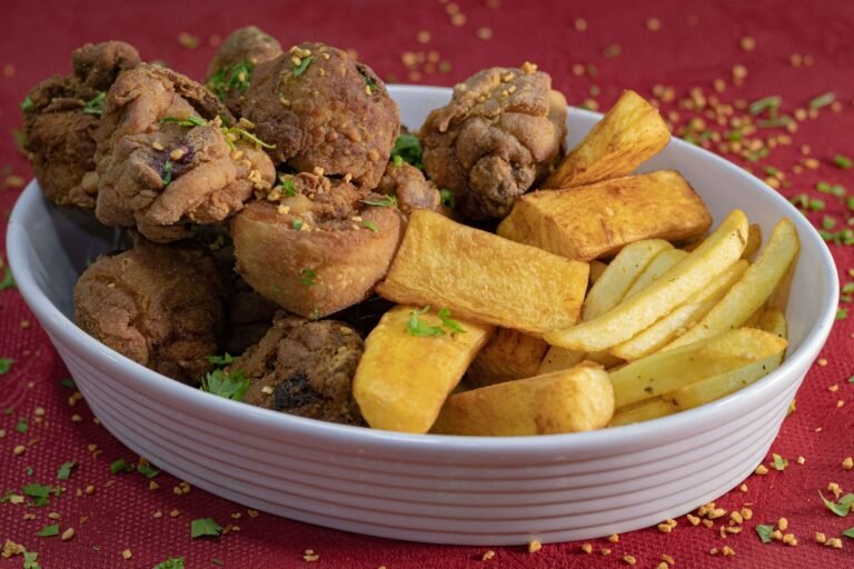 Savor a hearty plate of crispy fried chicken and golden fries garnished with herbs.