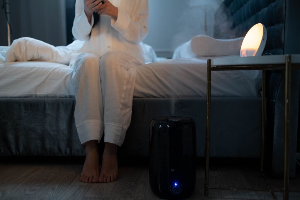 A serene bedroom scene with humidifier mist illuminating soft lighting, creating a calm atmosphere.