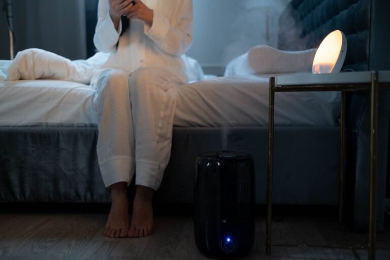 A serene bedroom scene with humidifier mist illuminating soft lighting, creating a calm atmosphere.