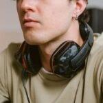 Close-up of a young man wearing a gaming headset while relaxed indoors.