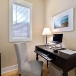 A tidy home office space with a wooden desk, laptop, and ambient lighting. Perfect for remote work.