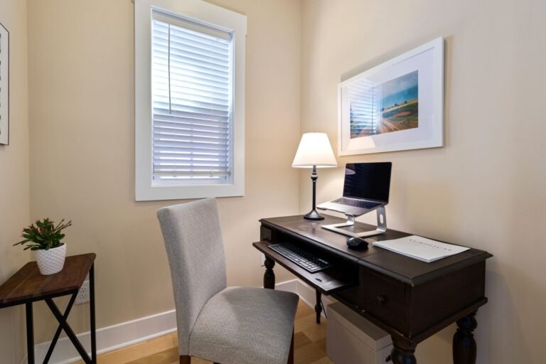 A tidy home office space with a wooden desk, laptop, and ambient lighting. Perfect for remote work.