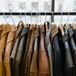 A collection of leather and suede jackets hanging on a clothes rack in a stylish boutique.