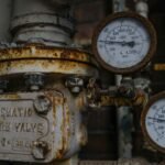 Close-up of an aged and rusted pressure valve with gauges showing readings.