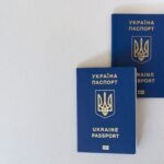 Two blue Ukrainian passports placed on a white surface, close-up view.